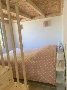 Schlafzimmer mit einem Bett mit Polka-Punkten-Bettwäsche in der Unterkunft Chalet Cocoon in Laroque