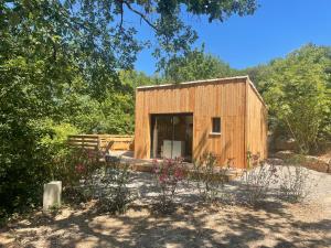 a small wooden shed with flowers in front of it at Chalet Cocoon in Laroque