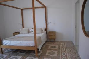 una camera con letto a baldacchino e tappeto di Palazzo Del Cavaliere a Gallipoli