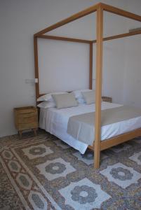 a bedroom with a canopy bed and a rug at Palazzo Del Cavaliere in Gallipoli +36 photos