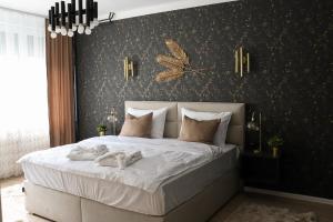 1 dormitorio con 1 cama grande y pared negra en 'NAP' apartment en Osijek