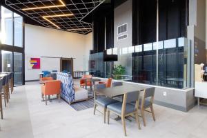 um átrio de escritório com mesas, cadeiras e janelas em Holiday Inn Express & Suites Phoenix - Tempe, an IHG Hotel em Tempe