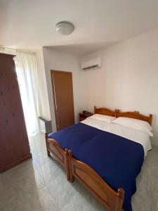 um quarto com uma cama com um cobertor azul em Petit gourmet em Siderno Marina