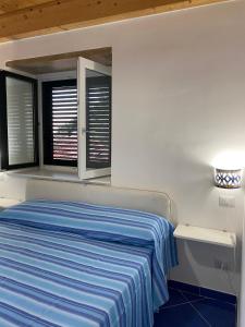 1 dormitorio blanco con 1 cama y 2 ventanas en Le Finestre di Amalfi, en Amalfi