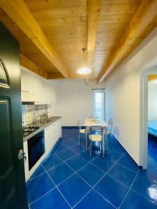 a kitchen with a table and a blue floor at Le Finestre di Amalfi in Amalfi
