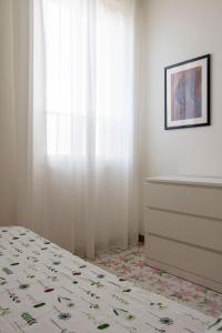 a bedroom with a bed and a dresser and a window at Casa Raffaela in Modica