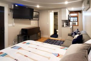 a living room with a bed and a flat screen tv at Nautical Daze- Studio in Oak Bluffs
