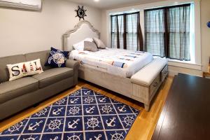 a bedroom with a large bed and a couch at Nautical Daze- Studio in Oak Bluffs