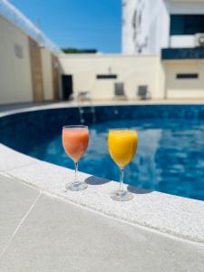 two wine glasses sitting next to a swimming pool at Hotel Saint Paul in Manaus