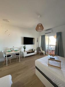 Sala de estar blanca con cama y mesa en Benalbeach Smart Suite, en Benalmádena