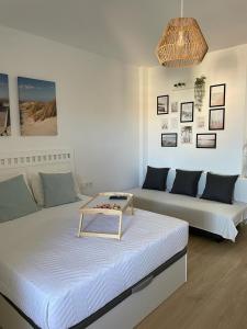 sala de estar con 2 camas y sofá en Benalbeach Smart Suite, en Benalmádena