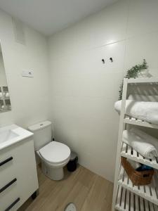 een witte badkamer met een toilet en een wastafel bij Benalbeach Smart Suite in Benalmádena