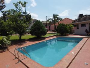 a swimming pool in front of a house at RugsResidence in Namugongo