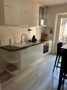 a white kitchen with a sink and a stove at Grazioso appartamento in zona centrale. in Montecatini Terme +6 photos