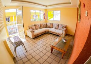 a living room with a couch and a table at Pousada Litoral in Porto De Galinhas +1 photo