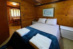1 dormitorio con 1 cama con 2 toallas en Chalé Dei Fiori, 3QTS, Ambiente Ideal para a família en Venda Nova do Imigrante