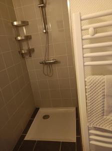y baño con ducha, lavabo y toallas. en Les Pierres Folles, en Rozier-en-Donzy