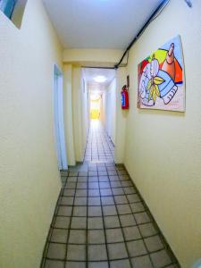 um longo corredor com piso em azulejo num quarto em Pousada Litoral em Porto de Galinhas