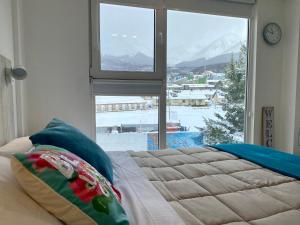 a bedroom with a bed and a large window with a view at AIRES DEL SUR in Ushuaia