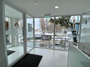 een kamer met glazen ramen en uitzicht op een tafel bij AIRES DEL SUR in Ushuaia