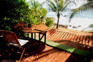 a wooden deck with a table and chair on the beach at Hotel Bendita Luna Salchi in Cuatunalco