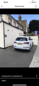 a white car parked in front of a garage at Spacious 2 bed Apartment with FREE PARKING for 2 cars and underground station Zone 2 for quick access to Central London up to 8 guests in London