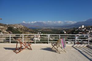 two chairs sitting on top of a balcony with a view at PanoramaKamil in Kamilari
