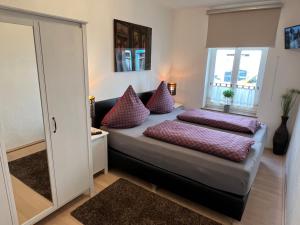 1 dormitorio con cama con almohadas y espejo en 3-Room Karl-Heine, en Leipzig