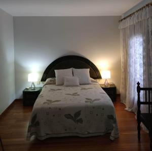 - une chambre avec un grand lit et deux lampes dans l'établissement Encantadora casa con piscina privada y vistas panorámicas, à Castellar de Santisteban