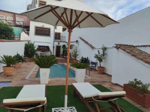 une terrasse avec un parasol, des chaises et une piscine dans l'établissement Encantadora casa con piscina privada y vistas panorámicas, à Castellar de Santisteban