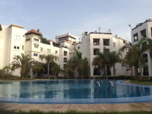 a swimming pool in front of some buildings at Marina Apartment Agadir in Agadir