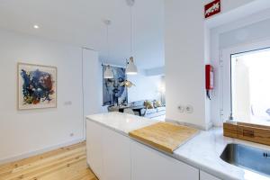 cocina blanca con fregadero y encimera en Modern & Charming Alges by GT House en Oeiras