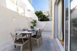 patio con mesa y sillas en el balcón en Modern & Charming Alges by GT House en Oeiras