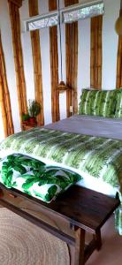 Un dormitorio con una cama con sábanas verdes y una mesa. en Hotel Bendita Luna Salchi, en Cuatunalco