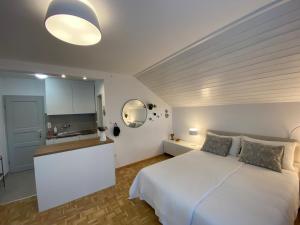 1 dormitorio con 1 cama blanca y cocina en Studio Tara with balcony en Bled