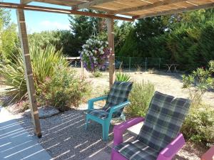 two chairs on a patio under a pergola at Chalet banane devant piscine, a 6km du festival de piano de la roque d'anthéron in Rognes