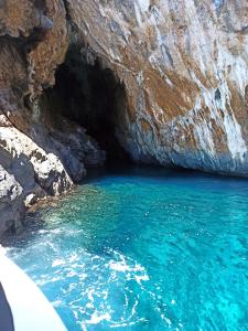 a cave with blue water in front of a cliff at B&b Anna's home in Marina di Camerota