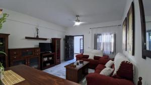 salon z czerwoną kanapą i stołem w obiekcie Apartamento Cabildo w mieście Sanlúcar de Barrameda