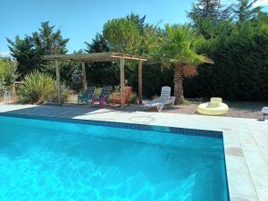 a swimming pool with chairs and a gazebo at Chalet banane devant piscine, a 6km du festival de piano de la roque d'anthéron in Rognes