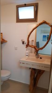 a bathroom with a sink and a mirror and a toilet at Rosewood in Kefar Weradim