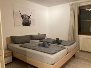 1 dormitorio con 1 cama con una foto de toro en la pared en Haus Waldblick, en Hopfgarten in Defereggen