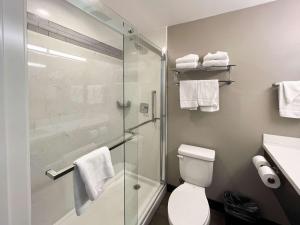 a bathroom with a toilet and a glass shower at Motel 6 Los Angeles, CA - Downtown in Los Angeles