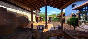un patio con mesas y bancos en un edificio en Hotel Rural Posada Del Monasterio, en Cangas de Onís