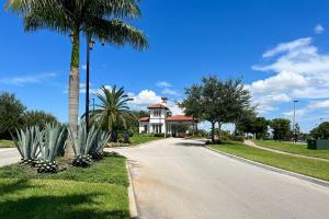 邁爾斯堡的住宿－Brand New Fort Myers Townhome Community Pool，棕榈树和道路的房子