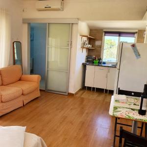 a living room with an orange couch and a kitchen at Seaside Studio in Sagres - 38 sqm with Terrace and Garden in Sagres
