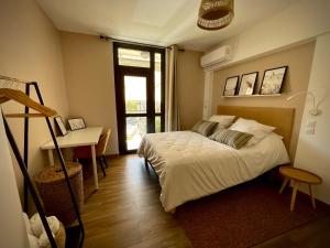 1 dormitorio con cama, escritorio y ventana en Très bel appartement central, au calme avec balnéo, en Perpiñán