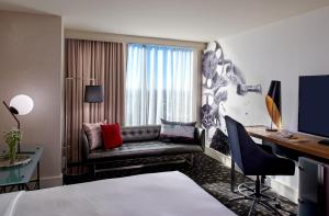 a hotel room with a bed and a desk and a couch at Kimpton Hotel Palomar Los Angeles Beverly Hills, an IHG Hotel in Los Angeles