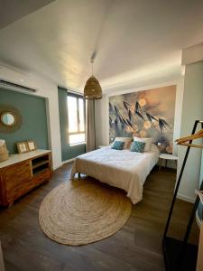 sypialnia z dużym łóżkiem i dużym dywanem w obiekcie Très bel appartement central, au calme avec balnéo w Perpignanie