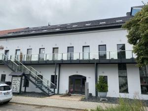 ein weißes Gebäude mit Balkon darüber in der Unterkunft Meisterhaus Apartments in Glauchau