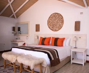 um quarto com uma cama grande com almofadas cor-de-laranja e preta em NOI Casa Atacama em San Pedro de Atacama